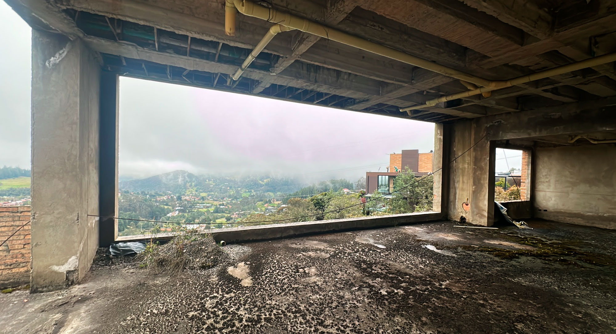 Casa AB3, La Calera: sala con chimenea lineal y ventanal al valle